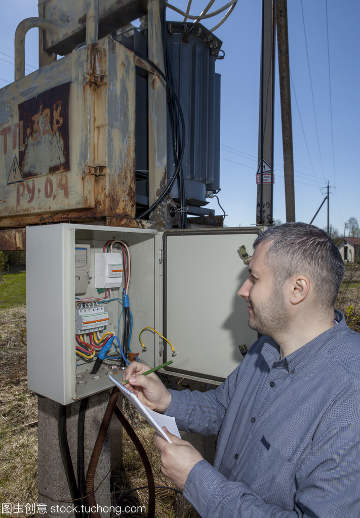 農村變電站,農夫檢查電力計數器檢查消費